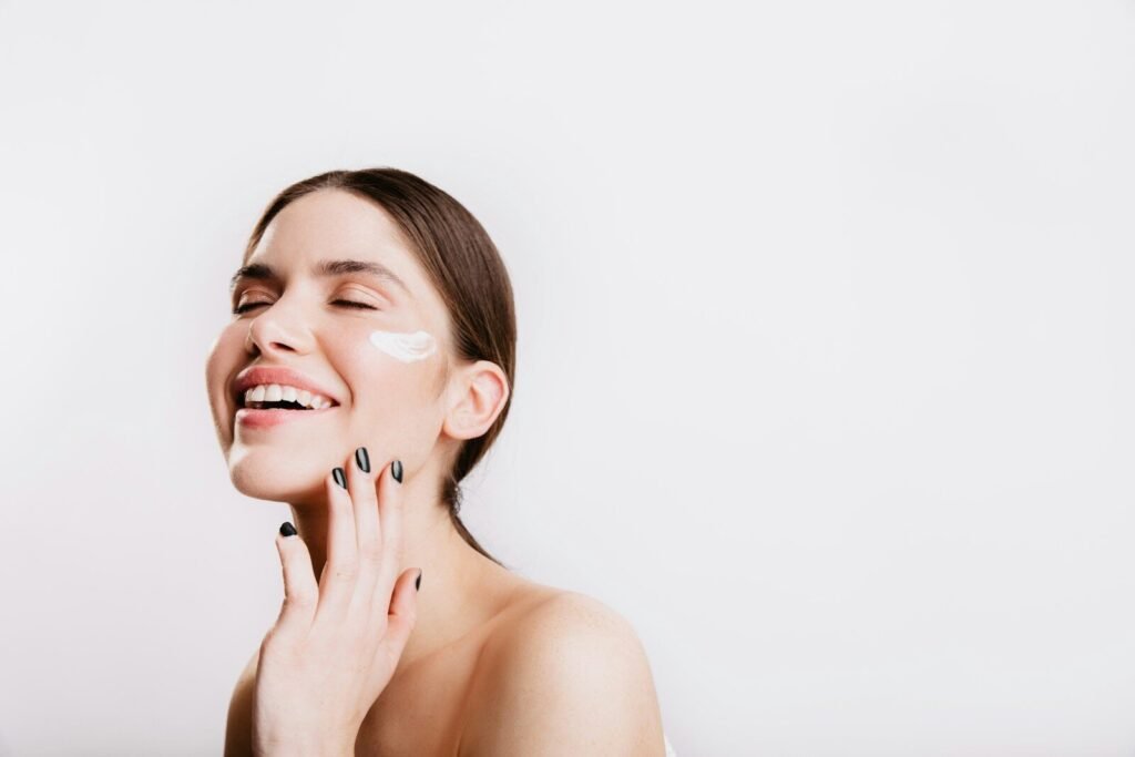 A woman smiles while she holds her hand to her face