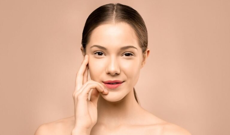 A close-up portrait of a young woman with flawless, radiant skin and a gentle smile, exuding natural beauty.