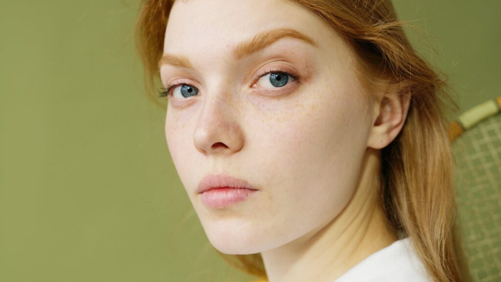 Detailed close-up portrait capturing a young woman's natural beauty and blue eyes.