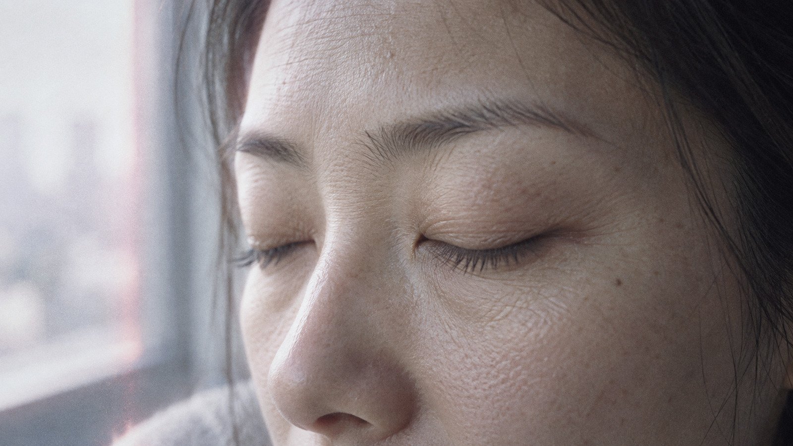 Close-up of a woman's eye area with her eyes softly closed