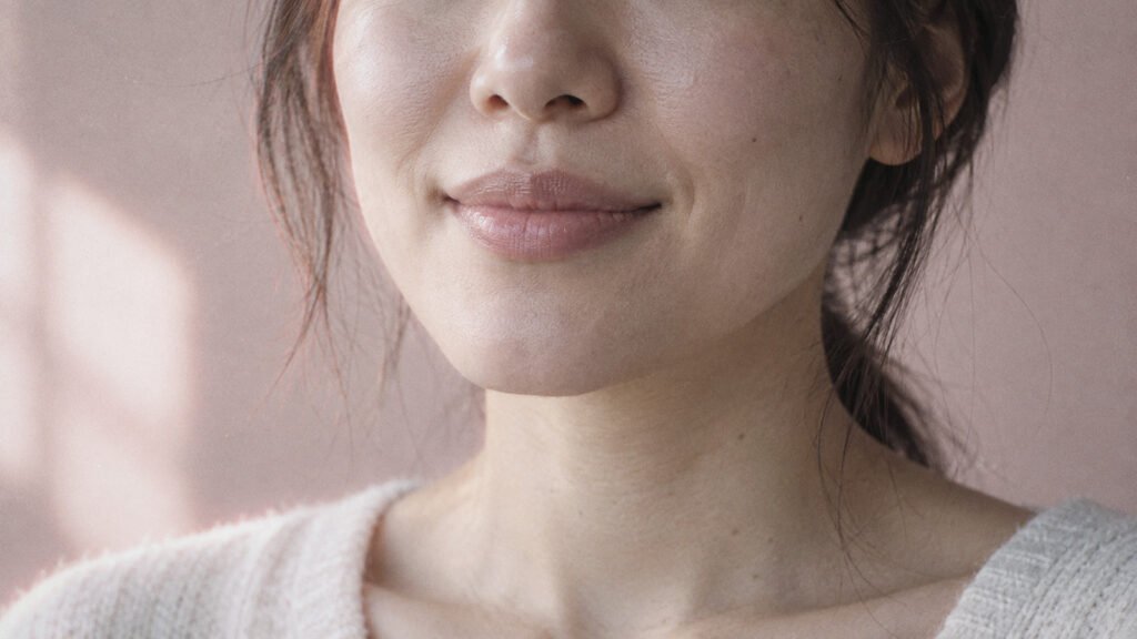 Close-up of a woman's lower face and natural lips with a gentle smile